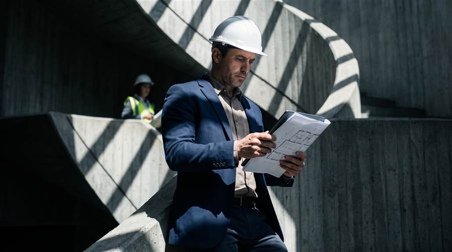 Construction project manager reviewing plans on site